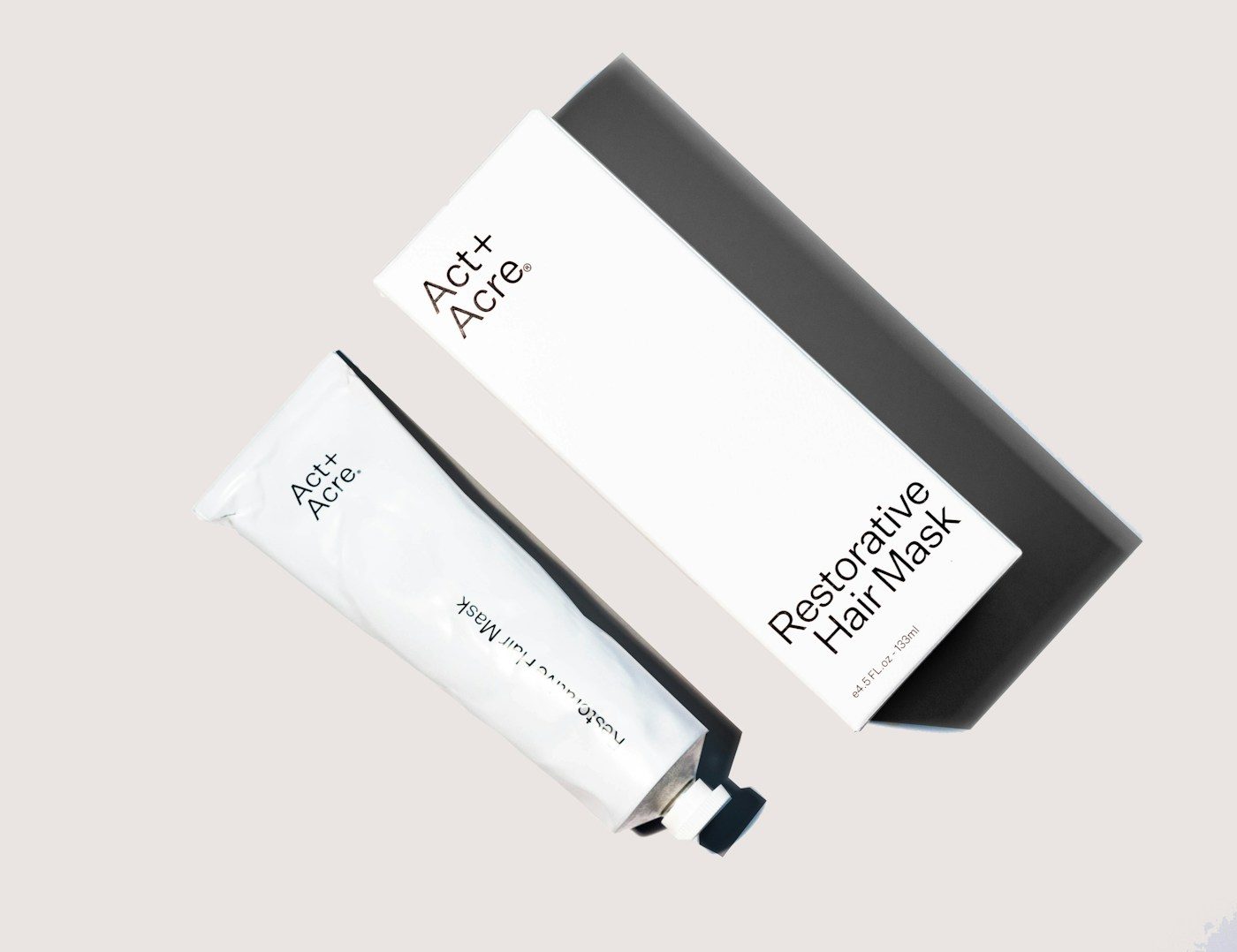 Warm, softly lit body balm and rose petals on a dark surface